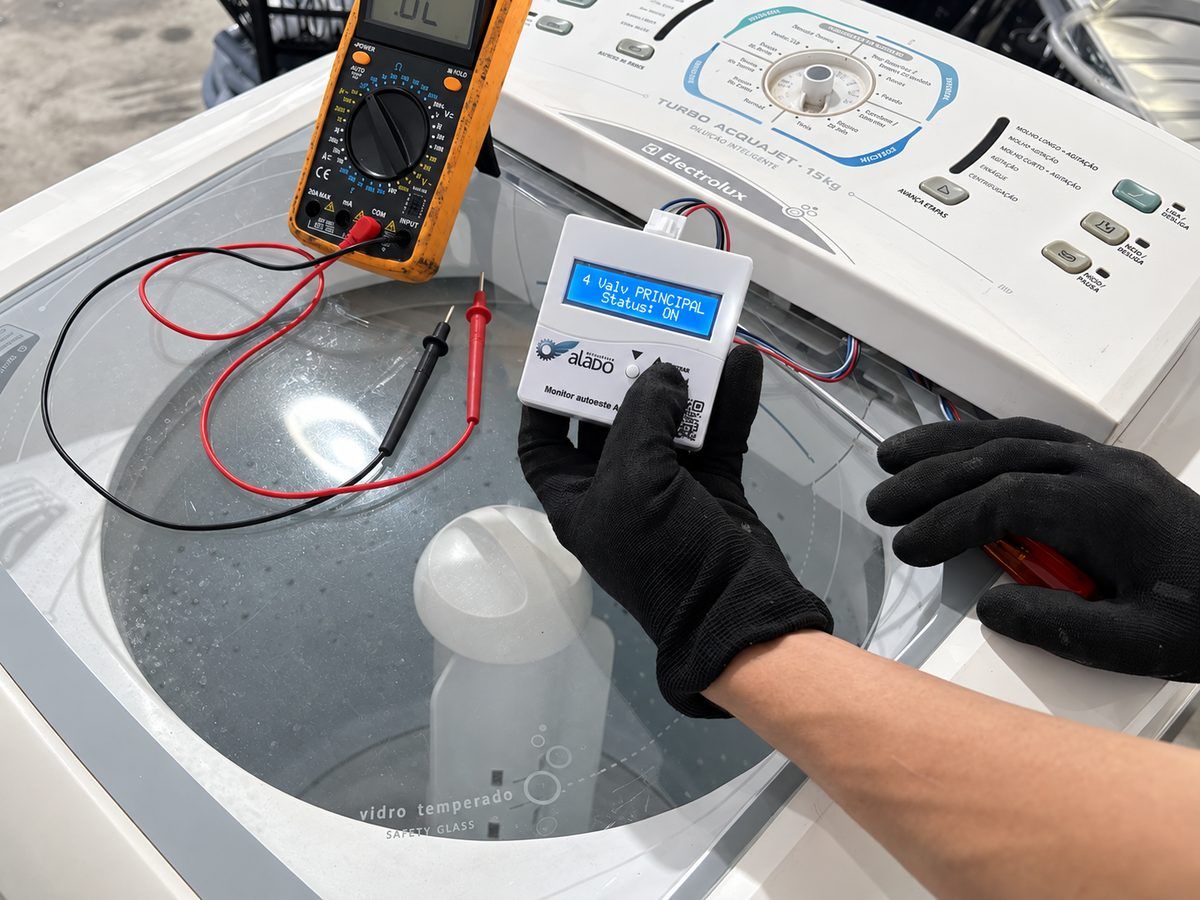 Técnico testando a placa de uma lavadora